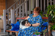 © Austockphoto - happy senior woman sitting on back porch with pet Papillon dog on her lap