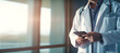 Banner with space for text Impersonal Male doctor in a white coat and with a tablet in his hands in the office.