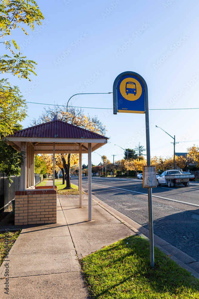 Bus stop sign and shelter on street of rural country town - public ...
