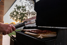 holding tongs while barbecuing