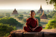 Buddhist young monk in meditation on cliff in Bagan, Myanmar