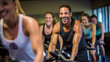Portrait of smiling man on exercise bike with friends  in gym