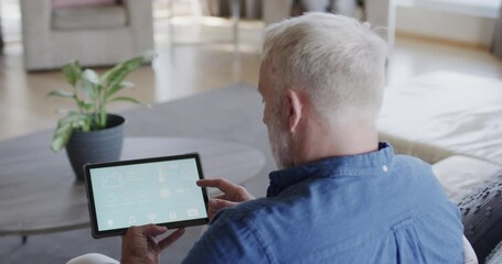 Wall Mural - middle aged caucasian man using tablet at home, copy space, slow motion