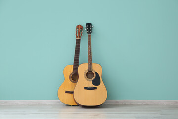 Two guitars near color wall