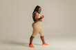 © gstockstudio - Full length of curvy African woman in sportswear radiating confidence