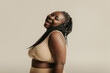 © gstockstudio - Voluptuous young African woman in underwear radiating joy and self-love on studio background