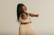© gstockstudio - Rear view of voluptuous African woman in sportswear exercising on studio background