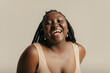 © gstockstudio - Portrait of curvy African woman looking at camera and smiling on studio background