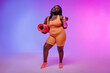© gstockstudio - Active young voluptuous woman in sportswear carrying exercise mat and smiling on pink background