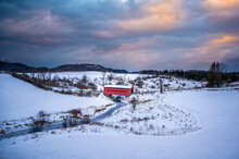 Red Covered Bridge In The Meech Creek Valley During Winter, With Colourful Dramatic Cloudy Sunset Sky, Gatineau Park, Chelsea, Quebec, Canada. Photo Taken During Hike In January 2022.