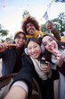 © CarlosBarquero - Vertical selfie phone looking camera of cheerful friends eating chocolate churros street food stall outdoors. Generation z tourist group of happy people having fun in terrace cafeteria in winter time