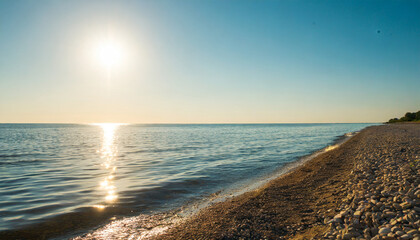 Wall Mural - summer seashore with calm water and golden sun reflection