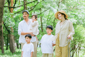 新緑の公園を歩く家族・ファミリー・家族旅行・レジャー
