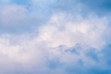 Wall Mural - Blue sky background with white and pink clouds at sunset