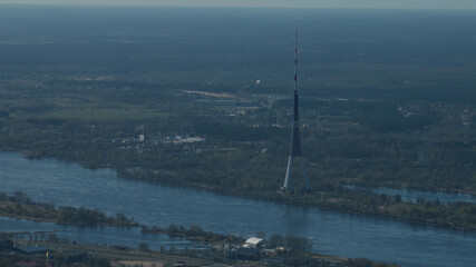 Canvas Print - Riga, Latvia - AUGUST 20 2023.  an aerial view of a river and a tower in the distance.