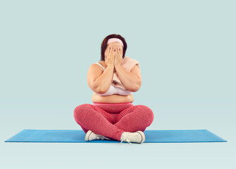 Reach perfect shape through exhausting workouts and tears. Sad tired fat overweight woman fails to lose weight, can't achieve ideal unattainable figure, loses hope, sits down on exercise mat and cries