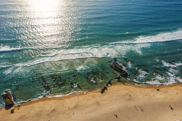 Wall Mural - ocean foamy waves approaching sandy shore. top view.