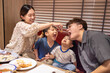© Tom Wang - Happy mother feeds her family in restaurant