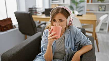 Sticker - Blonde boss babe alert! a young businesswoman serenading her office with music, while sipping on coffee, hard at work. beautiful serious worker immersed in her world indoors!