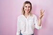 © Krakenimages.com - Young beautiful woman standing over pink background showing and pointing up with fingers number three while smiling confident and happy.