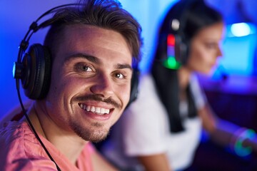 Wall Mural - Man and woman streamers playing video game using computer at gaming room