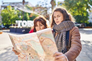 Poster - Two women mother and daughter looking city map with relaxed expression at park