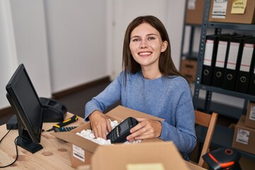 Canvas Print - Young blonde woman ecommerce business worker packing data phone on cardboard box at office