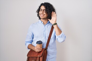 Wall Mural - Hispanic man with curly hair drinking a cup of take away coffee waiving saying hello happy and smiling, friendly welcome gesture