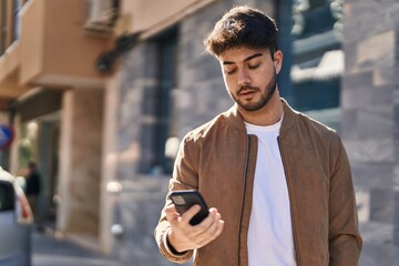 Canvas Print - Young hispanic man using smartphone at street