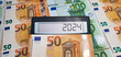 New challenges in 2024. Calculator on the background of 50 and 100 euro banknotes. Inflation, economic crisis, elections, war, recession, bankruptcy, cost of living, bills, poverty, migrants