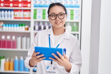 Sticker - Young chinese woman pharmacist using touchpad working at pharmacy