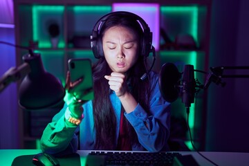 Canvas Print - Young asian woman playing video games with smartphone feeling unwell and coughing as symptom for cold or bronchitis. health care concept.