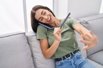 Sticker - Young beautiful hispanic woman talking on the smartphone doing manicure at home