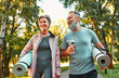 © HBS - Active life of older people. Happy sports couple going for a workout outdoors, holding exercise mats and water. Health and recovery, healthy living, hobbies in retirement.