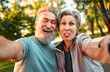 © HBS - Positive, cheerful, smiling gray-haired couple of senior people make a photo while grimacing. The man laughs, the woman shows her tongue funny. Senior people are emotionally happy and enjoying life.