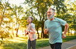 © HBS - Senior family couple jogging. Mature fitness people feeling contentment when running together in park. Cheerful loving spouses standing for healthy lifestyle and training every day outdoors.