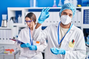 Wall Mural - Man and woman scientists holding pills reading document at street