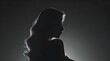 Silhouette of a beautiful woman with long hair on a dark background