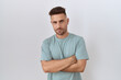 © Krakenimages.com - Hispanic man with beard standing over white background skeptic and nervous, disapproving expression on face with crossed arms. negative person.