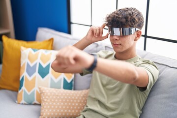 Poster - Young hispanic teenager playing video game using virtual reality glasses at home