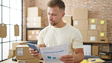 Canvas Print - Young man ecommerce business worker using smartphone reading document at office