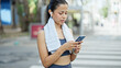 © Krakenimages.com - Young beautiful hispanic woman wearing sportswear using smartphone at street