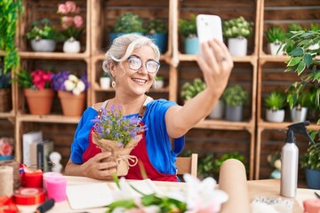 Sticker - Middle age grey-haired woman florist make selfie by smartphone holding lavender plant at florist