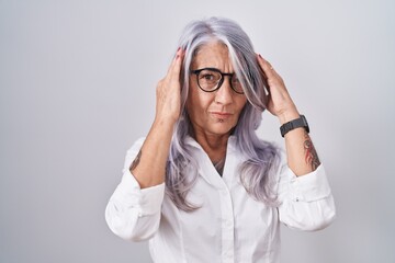 Sticker - Middle age woman with tattoos wearing glasses standing over white background with hand on head for pain in head because stress. suffering migraine.