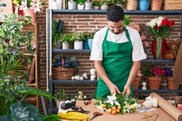 Wall Mural - Young arab man florist make bouquet of flowers at flower shop