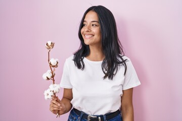 Sticker - Brunette woman standing over pink background looking away to side with smile on face, natural expression. laughing confident.