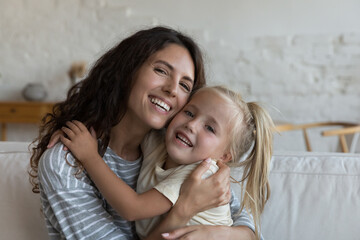 Wall Mural - Happy pretty mother and little daughter hugging with face touch, smiling, laughing, looking at camera, enjoying connection, close relationship, family leisure time, happiness