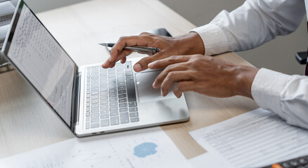 Man working by using a laptop computer Hands typing on keyboard