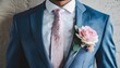 Détail de l'élégance : boutonnière rose sur un costume de marié