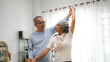 © Stella 16 - Selective focus of senior couple holding hands while dancing in living room